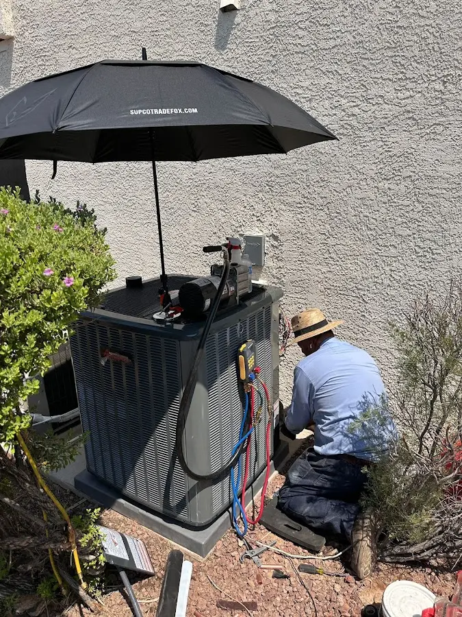 HVAC technician performing outdoor AC maintenance in Bell